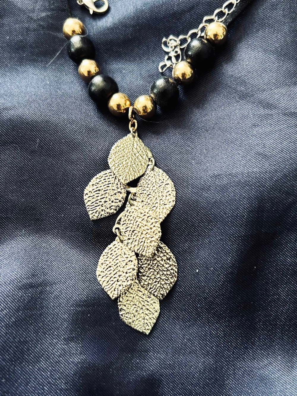 NECKLACE 7 SMALL TEXTURED METAL LEAVES WITH BLACK/GOLD BEADS ON SUEDE CORD,